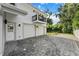 Two-car garage with paver driveway and a private balcony above at 1616 E Marks St, Orlando, FL 32803