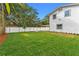 Spacious backyard with a grassy lawn, privacy fence, and mature trees at 1616 E Marks St, Orlando, FL 32803