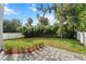 Private backyard oasis with brick pavers, lush landscaping, and a fence at 1616 E Marks St, Orlando, FL 32803