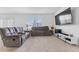 Living room featuring gray reclining sofas and a large TV at 821 Sun Burst Rd, Winter Haven, FL 33880