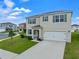 Two-story house with a two-car garage, landscaping, and a teal front door at 821 Sun Burst Rd, Winter Haven, FL 33880