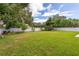 Large backyard with lush grass, privacy fence, and mature trees at 905 Marabon Ave, Orlando, FL 32806