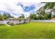 Spacious backyard with grassy lawn, privacy fence, and mature trees at 905 Marabon Ave, Orlando, FL 32806