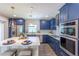 Modern kitchen with navy blue cabinetry, stainless steel appliances, and a large island at 905 Marabon Ave, Orlando, FL 32806