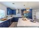 Updated kitchen featuring navy blue cabinets, a large island, and stylish light fixtures at 905 Marabon Ave, Orlando, FL 32806