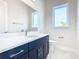 Modern bathroom with dark navy vanity and a white quartz countertop at 1020 Jack Nicklaus Ct, Kissimmee, FL 34747