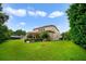 House back elevation showing a large grassy backyard and lush landscaping at 1563 Song Sparrow Ct, Sanford, FL 32773