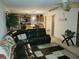 Open living room featuring a large black sectional sofa and kitchen views at 15507 Willet Ct, Mascotte, FL 34753