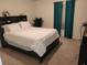 Bedroom with a queen-size bed and teal curtains at 15507 Willet Ct, Mascotte, FL 34753