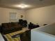 Cozy bonus room with a brown couch and a striped rug at 15507 Willet Ct, Mascotte, FL 34753