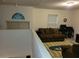 Bright bonus room with a couch and large window at 15507 Willet Ct, Mascotte, FL 34753