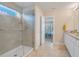 Modern bathroom with a walk-in shower, granite vanity, and view into bedroom at 1001 Rivers Crossing St, Clermont, FL 34714