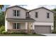 Two-story home with gray siding, stone accents, and a two-car garage at 3579 Dahlia Dr, Lake Hamilton, FL 33851