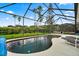 Inviting kidney-shaped pool with a screened enclosure and patio furniture at 2907 Sunset Lakes Blvd, Kissimmee, FL 34747