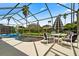 Screened-in pool and patio with table and chairs for outdoor dining at 2907 Sunset Lakes Blvd, Kissimmee, FL 34747
