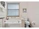 Bathroom with a walk-in tub, toilet and window at 2907 Sunset Lakes Blvd, Kissimmee, FL 34747
