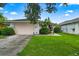 House exterior with a pink garage door and manicured lawn at 2907 Sunset Lakes Blvd, Kissimmee, FL 34747