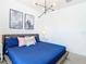 Bedroom with a blue comforter and geometric art at 8976 Amelia Downs Trl, Kissimmee, FL 34747