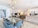 Bright dining room with glass table, modern chandelier and view to kitchen at 8976 Amelia Downs Trl, Kissimmee, FL 34747