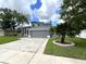 Two-story house with gray siding, palm trees, and a paved driveway at 14534 Potanow Trl, Orlando, FL 32837