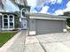 Two-story house with gray siding, white accents, and a paved walkway leading to the entrance at 14534 Potanow Trl, Orlando, FL 32837