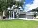 Two-story house with gray siding, landscaped lawn, and a two-car garage at 14534 Potanow Trl, Orlando, FL 32837