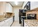 Modern kitchen with granite counters and black appliances at 4316 S Kirkman Rd # 1602, Orlando, FL 32811
