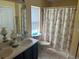 Bathroom with double vanity, shower/tub combo, and floral shower curtain at 4260 Climbing Aster Ct, Saint Cloud, FL 34772