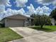One-story house with a gray exterior and green lawn at 4260 Climbing Aster Ct, Saint Cloud, FL 34772