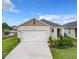 White house with a two-car garage and landscaping at 2222 Elmsford Pt, Sanford, FL 32771