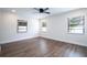 Bright bedroom with three windows, wood-look floors, and ceiling fan at 1124 Munster St, Orlando, FL 32803