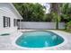 Inviting kidney-shaped pool with a gray stone deck and white fence at 1124 Munster St, Orlando, FL 32803