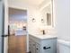 Modern bathroom with updated vanity, a large illuminated mirror, and view of kitchen at 1124 Munster St, Orlando, FL 32803