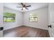 Bright bedroom with wood-look floors, ceiling fan, and ample closet space at 1124 Munster St, Orlando, FL 32803