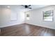 Bright bedroom with three windows, wood-look floors, and ceiling fan at 1124 Munster St, Orlando, FL 32803