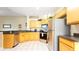 Well-equipped kitchen with wood cabinets, stainless steel appliances, and dark countertops at 441 Montara Dr, Davenport, FL 33897