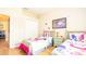 Bedroom with two twin beds, Trolls-themed bedding, and wood floors at 441 Montara Dr, Davenport, FL 33897