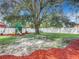Spacious backyard with a large tree, playground, and red mulch at 1092 Providence Blvd, Deltona, FL 32725