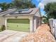 Attached garage with green door and solar panels on roof at 1092 Providence Blvd, Deltona, FL 32725
