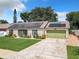 Aerial view of a house with solar panels, green garage door, and landscaped yard at 1092 Providence Blvd, Deltona, FL 32725