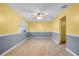 Spacious dining room with light yellow and gray walls, tile floors, and a ceiling fan at 1005 Crescent Pkwy, Deland, FL 32724