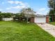 Brick house with a large front yard, driveway, and solar panels at 1005 Crescent Pkwy, Deland, FL 32724