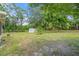 Large backyard with grassy area, mature trees, and a storage shed at 3133 Bon Air Dr, Orlando, FL 32818