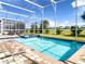 Enjoy this screened-in pool and spa with a spacious deck and tranquil backyard view at 791 Pebble Beach Dr, Davenport, FL 33896