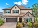 Two-story house exterior, stone accents, brown garage door, and landscaping at 5232 Villa Rosa Ave, St Cloud, FL 34771
