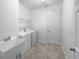 Bright laundry room featuring washer, dryer, utility sink, and ample shelving at 5408 Manchester Dr, St Cloud, FL 34771