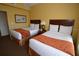 Guest bedroom with two twin beds and orange accents at 8125 Resort Village Dr # 3514, Orlando, FL 32821