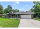 A charming house with a gray exterior, white garage door, and a neatly landscaped lawn at 668 Coral Way, Winter Springs, FL 32708