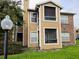 Tan and brick condo building with green accents at 4401 Thornbriar Ln # 202, Orlando, FL 32822