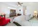 Spacious main bedroom with a king-size bed and red accent chair at 5637 Beggs Rd, Saint Cloud, FL 34771